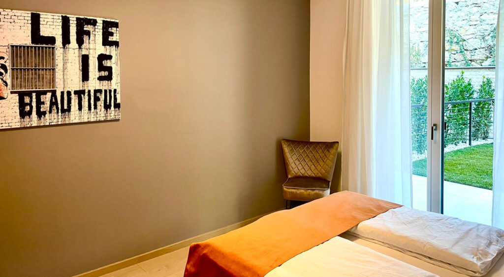 teaser-apartment-il-sogno-al-lago-di-garda-luxus-ferienwohnung-lage-oranges-schlafzimmert