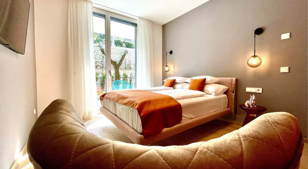 teaser-9-schlafzimmer-orange-couch-luxus-ferienwohnung-gardasee